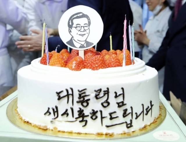 문재인 대통령이 2019년 1월 24일 오후 전국경제투어로 대전을 방문, 대전의 명물 성심당 빵집에서 튀김 소보로를 구매한 후 직원들로부터 깜짝 생일 축하 케이크를 받고 있다. 연합뉴스