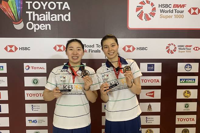배드민턴 대표팀 여자 복식 공희용(왼쪽)-김소영이 24일 HSBC 세계배드민턴연맹(BWF) 월드 투어 슈퍼 1000 토요타 태국오픈에서 정상에 오른 뒤 금메달과 우승 트로피를 들고 포즈를 취하고 있다. 방콕=대한배드민턴협회