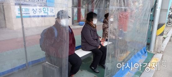 시민들이 버스승강장에서 앉으면 따뜻해 지는 탄소발열에어벤치를 이용하고 있다.
