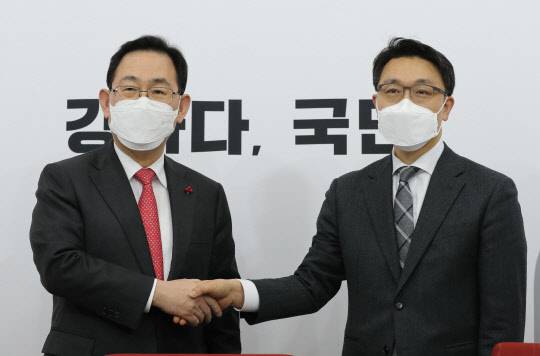 주호영 국민의힘 원내대표와 김진욱 초대 공수처장이 26일 국회에서 만나 악수를 나누고 있다. 연합뉴스