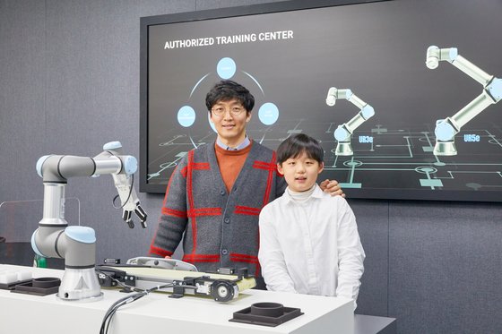 유니버설 로봇 코리아를 찾은 한현 학생기자가 백승민(왼쪽) 팀장과 나란히 섰다. 협동 로봇은 인간과 협업하며 생산성을 높여준다는 장점이 있다.