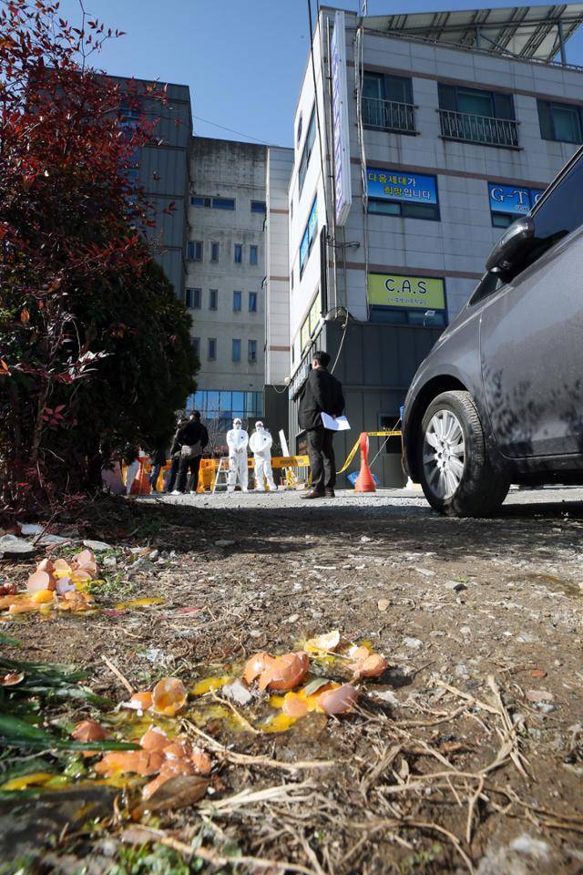 신종 코로나바이러스 감염증(코로나19) 집단 확진이 발생한 광주 광산구 운남동 광주 TCS 국제학교에서 한 시민이 던지려던 계란이 경찰의 제지로 바닥에 깨져 있다. 이곳에서는 120여명이 합숙 생활을 하다가 113명이 코로나19에 확진됐다. 연합뉴스
