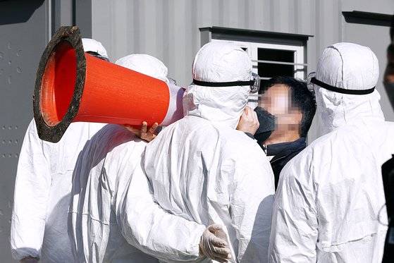 코로나19 집단감염이 발생한 광주 광산구 TCS 국제학교 앞에서 27일 오후 한 시민이 '안전 고깔(라바콘)'을 확성기 삼아 시설 운영 주체인 종교단체에 항의하고 있다. 장정필 기자