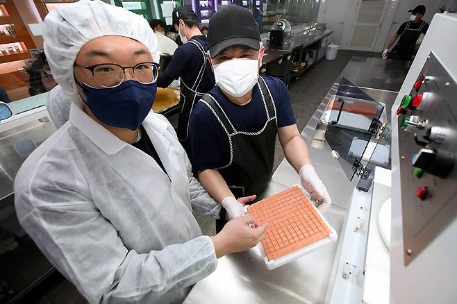 자동으로 절단된 감귤젤리를 들어 보이고 있는 고정범 박사(왼쪽)와 강민식 캔디원 대표.[한국생산기술연구원 제공]