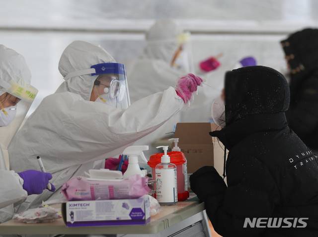 [제주=뉴시스]제주시보건소에 마련된 코로나19 선별진료소에서 의료진들이 검체 채취를 하고 있다. (사진=뉴시스DB)