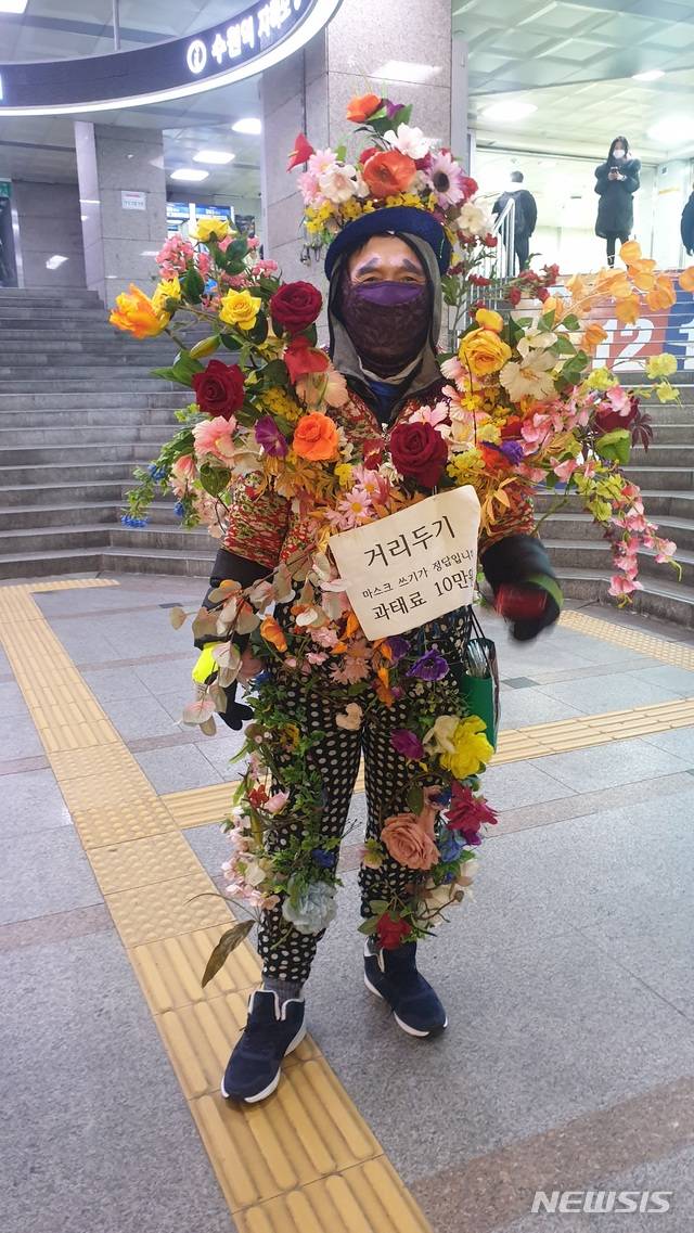[수원=뉴시스] 수원역 일대에서 방역수칙 캠페인 벌이는 꽃아저씨. (사진=독자제공)
