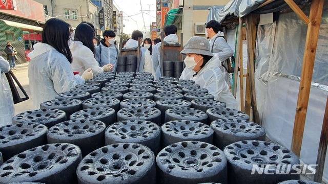 [춘천=뉴시스]김유나 기자 = 27일 오후 강원 춘천시 소양로에서 강원대학교 학생들이 취약 가구에 연탄을 나르고 있다. 2021.01.27. una@newsis.com