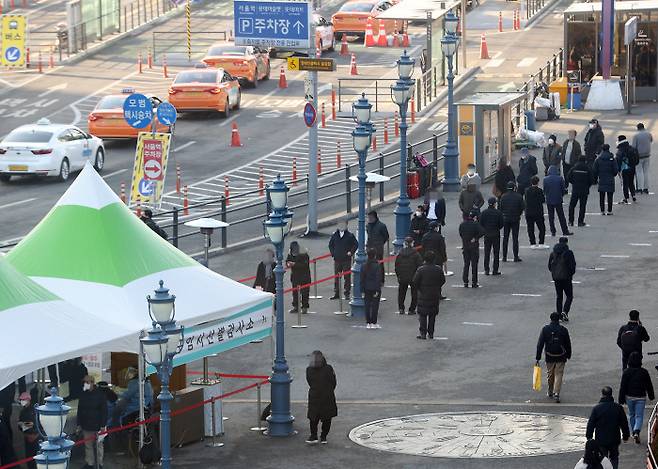 27일 오전 서울역광장에 설치된 임시선별진료소에서 시민들이 코로나19 검사를 받기 위해 줄을 서고 있다. 연합뉴스