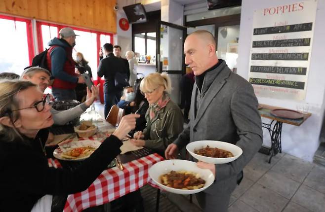 영업 금지령에 정면으로 도전한 포피 주인 크리스토프 윌슨이 음식을 손님들에게 나르고 있다./니스 마탱