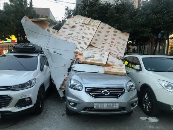 28일 부산경찰청에 따르면 이날 오후 5시 37분께 부산 연제구 한 빌라 외벽 마감재가 강풍에 떨어져 나가 지상에 주차돼 있던 차량 3대를 덮쳤다. 차량 덮친 건물 마감재. /연합뉴스