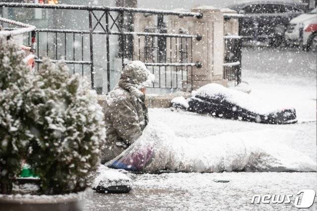 대설주의보가 발효된 28일 서울역광장에서 한 노숙인이 내리는 눈을 바라보며 앉아 있다. 서울=뉴스1