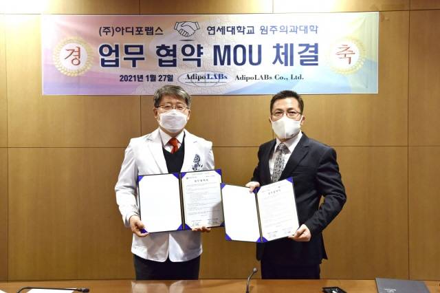 원주 연세대학교 의과대학 이강현 학장(왼쪽)과 아디포랩스 한성호 대표이사가 지난 27일 진행된 업무 협약식에서 기념사진을 촬영하고 있다./아디포랩스 제공