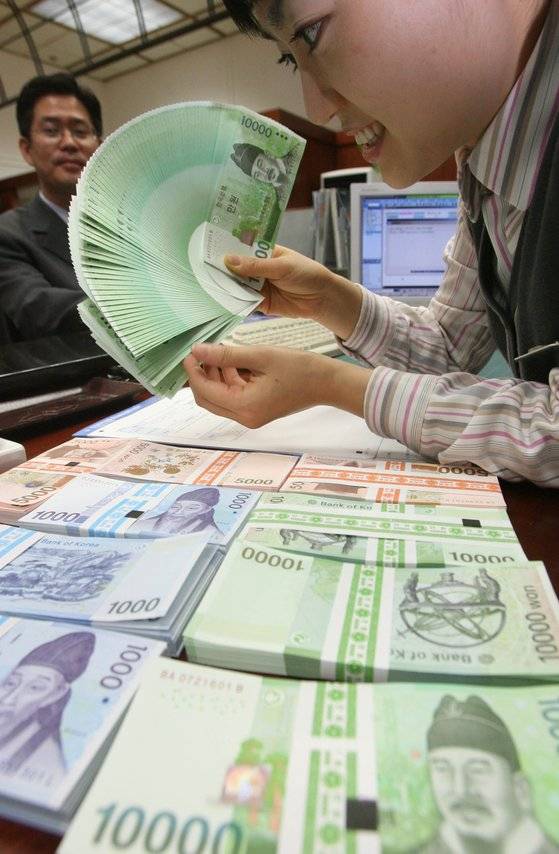 지난해 설을 앞두고 은행직원이 신권으로 바꿔주고 있다. 신한은행 본점에서 [중앙포토]