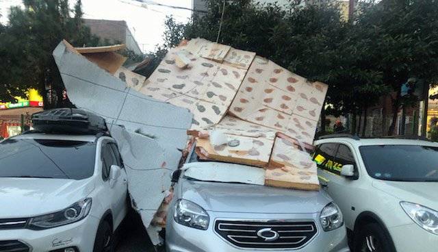 부산지역에 강풍주의보가 발효된 28일 오후 연제구의 한 빌라 9~10층 외벽에서 마감재가 강풍에 떨어져 지상에 주차된 차량 3대를 덮쳤다. 사진 부산경찰청=뉴시스