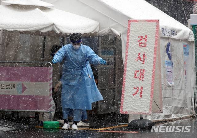 [서울=뉴시스]고승민 기자 = 서울지역에 대설주의보가 발효된 28일 국립중앙의료원 선별진료소에서 의료진이 제설제를 도로에 뿌리고 있다. 2021.01.28. kkssmm99@newsis.com