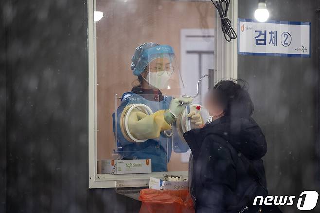지난 28일 서울역광장에 마련된 신종 코로나바이러스 감염증(코로나19) 중구임시선별검사소를 찾은 한 시민이 코로나19 검체채취를 하고 있다. 2021.1.28/뉴스1 © News1 유승관 기자