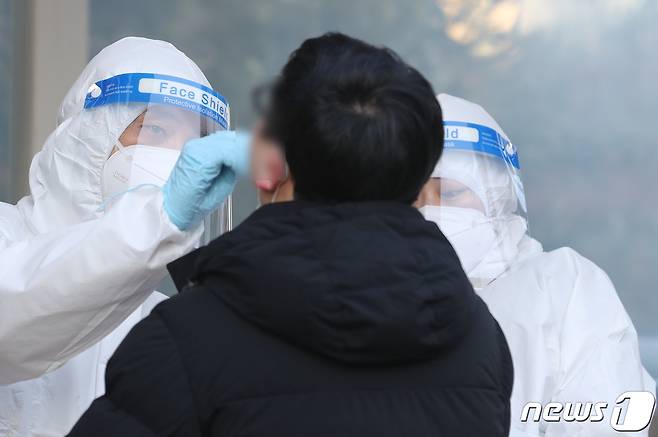 선별진료소 의료진이 피검사자의 검체를 검사하고 있다./뉴스1 © News1 이재명 기자