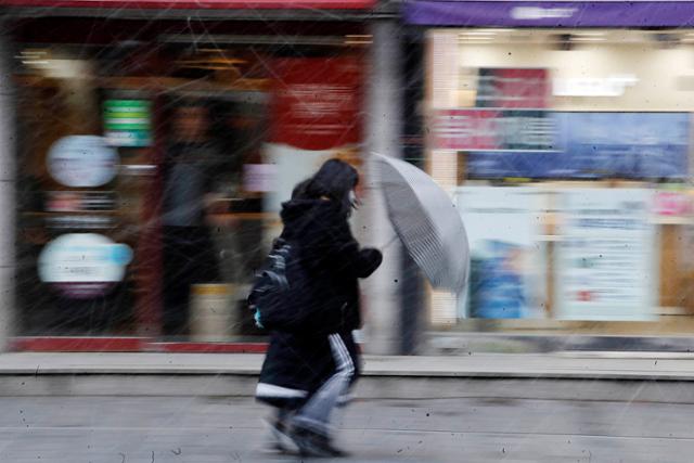 지난 28일 오후 광주 북구 전남대학교 인근 거리에서 강풍과 함께 내리는 눈에 시민들이 힘겨워하고 있다. 광주 북구청 제공