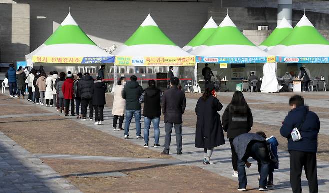28일 광주 서구 시청광장에 마련된 임시 선별검사소에 코로나19 검사를 받으려는 시민들이 길게 줄 서 있다.  연합뉴스