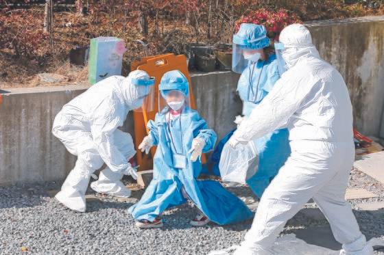 아이엠(IM) 선교회가 운영하는 광주의 비인가 교육시설 TCS 국제학교에서 합숙생활을 하던 학생과 교직원 등이 코로나19에 집단 감염됐다. 27일 이 학교에서 한 어린이가 몸에 맞지 않는 방호복을 입고 치료센터로 가는 버스로 이동하고 있다. 프리랜서 장정필