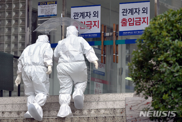 [대구=뉴시스] 이무열 기자 = 대구에 비가 내리는 26일 오후 대구 중구 계명대학교 대구동산병원에서 근무 교대를 위해 방호복을 착용한 의료진이 우산을 쓰고 신종 코로나바이러스 감염증(코로나19) 격리병동으로 들어가고 있다. 2021.01.26. lmy@newsis.com