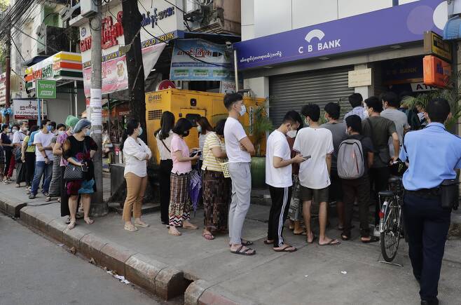 1일(현지 시각) 미얀마 도시 양곤의 한 ATM 기기 앞에 길게 줄을 선 사람들. 이날 미얀마은행연합회는 은행 업무를 일시 중단한다고 밝혔다. /EPA 연합뉴스