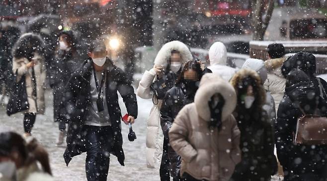 눈이 크게 내린 지난달 12일 저녁 서울 강남역 인근에서 시민들이 퇴근길을 재촉하고 있다. 연합뉴스 제공