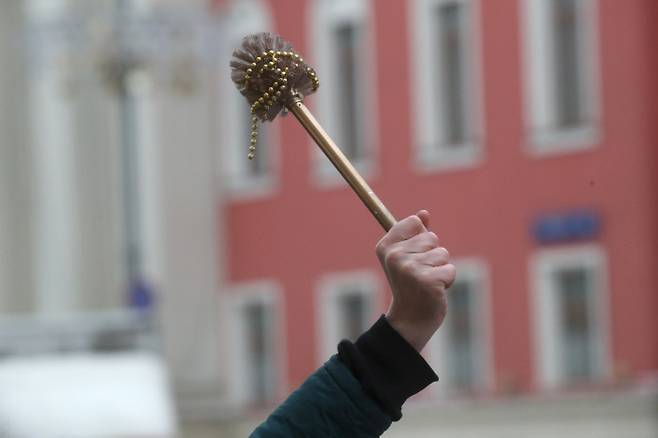 러시아 야권 지도자 알렉세이 나발니의 석방을 촉구하는 시위가 열린 지난달 23일(현지시간) 한 시위 참가자가 모스크바 트베르스카야 거리에서 정부 저항의 상징인 황금색 변기솔을 치켜들고 있다.  모스크바 | 타스연합뉴스