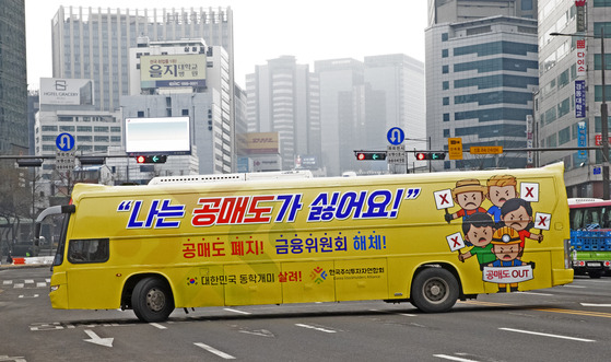 The Korea Stockholders Alliance, a group of local retail investors, operates a bus decorated with slogans promoting the short-selling ban at Gwanghwamun in central Seoul on Monday. [YONHAP]