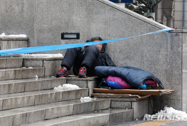 [서울=뉴시스]김병문 기자 = 노숙인이 28일 오전 서울 용산구 서울역광장에서 휴식을 취하고 있다. 신종 코로나바이러스 감염증(코로나19) 확진자가 발생한 서울역 희망지원센터는 지난 26일부터 운영이 중단되고 있다. 2021.01.28.  dadazon@newsis.com