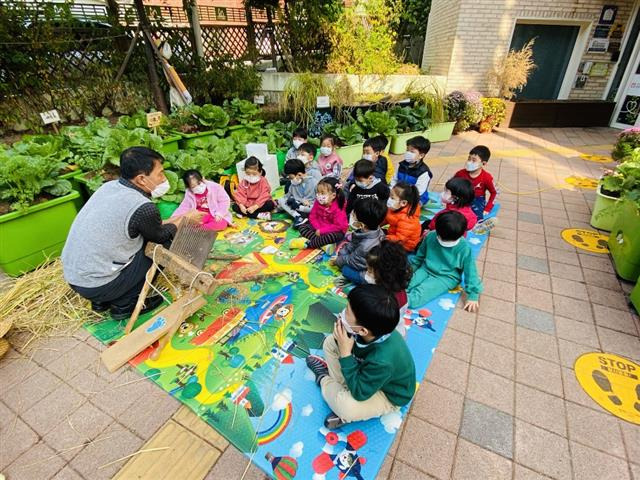 서울 서초구가 전국에서 처음으로 선보인 공유 어린이집은 벼 타작 체험(사진), 목공 놀이 등 다양한 교육 프로그램을 공동으로 진행해 학부모들의 만족도가 높다.서초구 제공