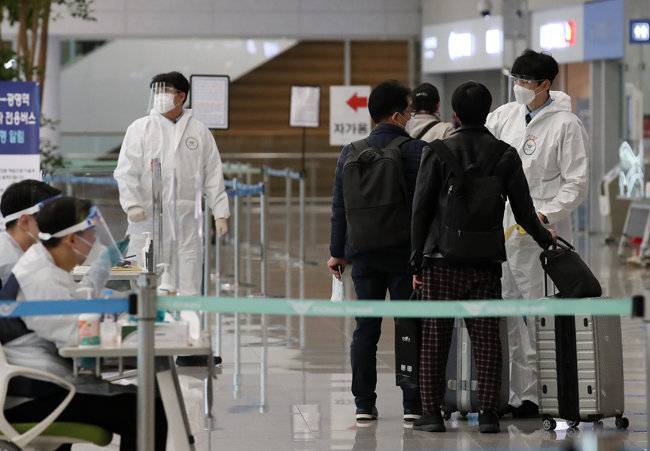 지난해 12월 31일 오후 인천국제공항 제2터미널 입국장에서 입국자가 방역 당국의 안내를 받고 있다. [뉴스1]