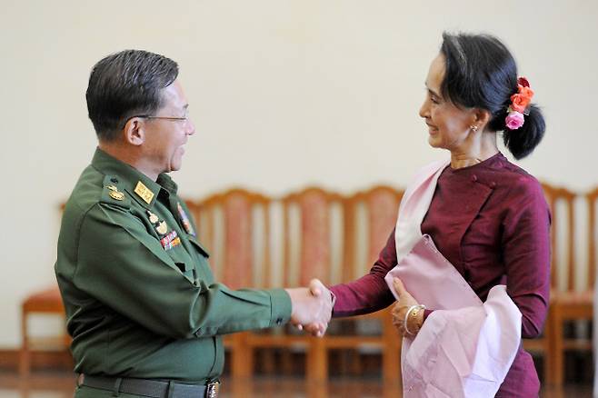 Min Aung Hlaing (left), the commander-in-chief of the Myanmarese military shakes hands with state advisor Aung San Suu Kyi, the leader of the ruling National League for Democracy (NLD), in his office in Naypyitaw, the nation’s capital on December 2, 2015. On February 1, the military-owned TV station reported, “The military declared a year of a state of emergency in response to the election fraud last November.” The military detained senior government officials including state advisor Aung San Suu Kyi and President Win Myint and transferred power to the commander-in-chief Min Aung Hlaing. Naypyitaw / AFP Yonhap News