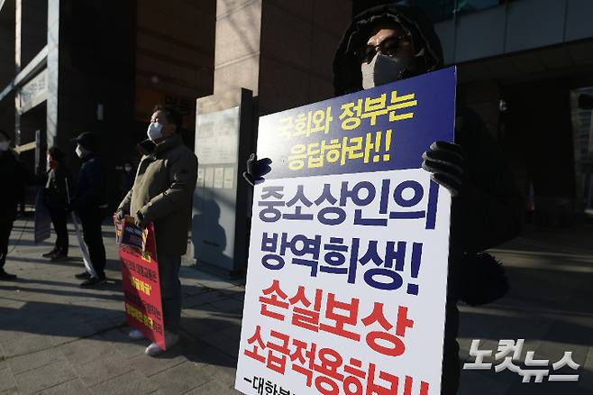 '거리두기 단계 개편을 위한 공개토론회'가 열린 2일 서울 중구 LW컨벤션 앞에서 자영업자들이 1인 시위를 나서며 영업시간 연장 등을 촉구하고 있다. 이한형 기자