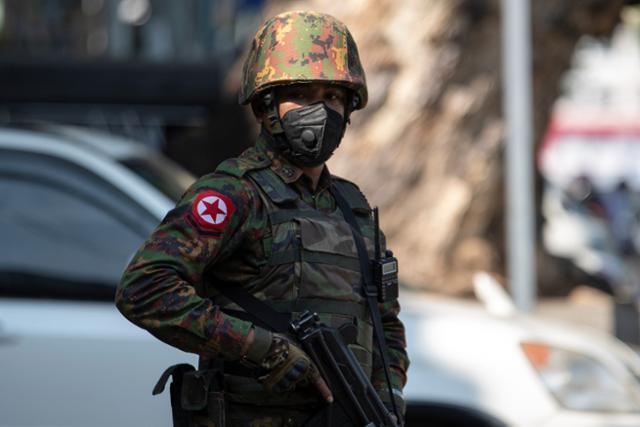 총으로 무장한 미얀마 군인이 2일 최대 도시 양곤 인근의 한 사원 앞에서 삼엄한 경계를 펴고 있다. 양곤=로이터 연합뉴스