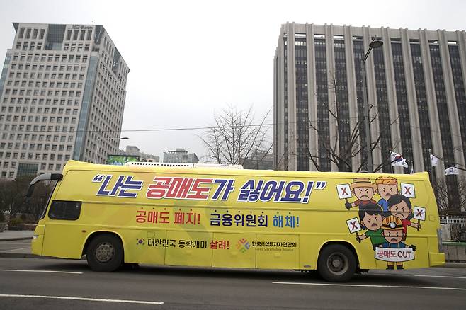 Demanding an outright ban on short selling, members of an advocate group of retail investors are driving a bus painted with messages like “I hate short selling” in front of the government complex building in Seoul on Feb. 1, 2021. (Yonhap)