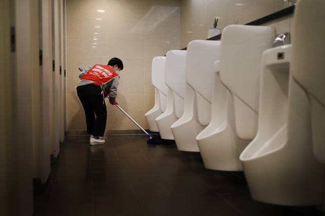 ▲ LG트윈타워 화장실 바닥을 닦고 있는 청소노동자. ⓒ프레시안(최형락)