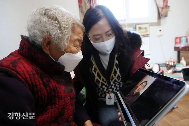 양계순 할머니(85)가 설연휴를 이틀 앞둔 9일 오후 경북 의성군 점곡면의 자택에서 조경화 생활지원사의 도움을 받아 설에 오지 못하는 딸 남상기씨의 영상편지를 보고 있다. 지난 추석에도 고향을 방문하지 못한 남씨는 영상에서 “엄마, 이제 곧 백신도 맞으니 백신 맞으면 꼭 보자”며 눈시울을 붉혔다.  의성｜권도현 기자