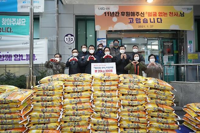 11년째 매년 설 무렵 ‘얼굴 없는 천사’가 서울 성북구 월곡2동 주민센터에 20㎏ 쌀 300포를 기부했다. 2021년 1월27일 아침 이승로 성북구청장을 비롯한 구청·동 주민센터 직원과 주민들이 배달 온 트럭에서 쌀 포대를 내리고, 쌀 앞에서 ‘천사’에게 감사의 ‘하트’를 날렸다.