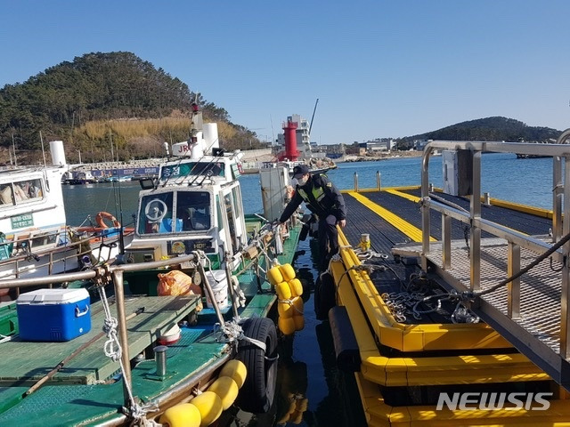 [부산=뉴시스] 기상악화에 대비해 부산 송정항에서 해양경찰관이 선박 계류상태를 점검하고 있다. (사진=부산해경 제공)