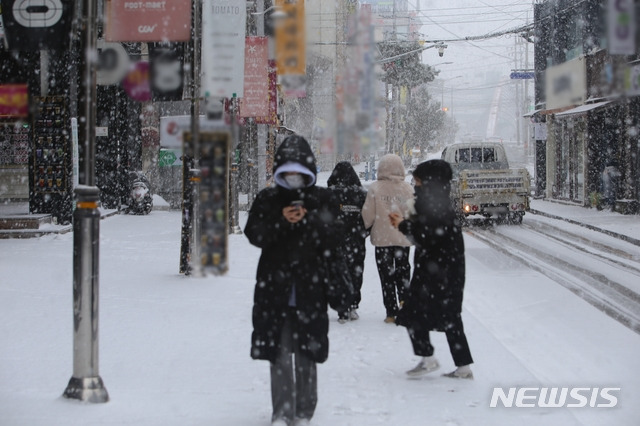 [청주=뉴시스] 조성현 기자 = 대설주의보가 발효 중인 16일 오후 충북 청주시 상당구 한 거리에서 시민이 눈을 맞으며 걸어가고 있다. 2021.02.16. jsh0128@newsis.com