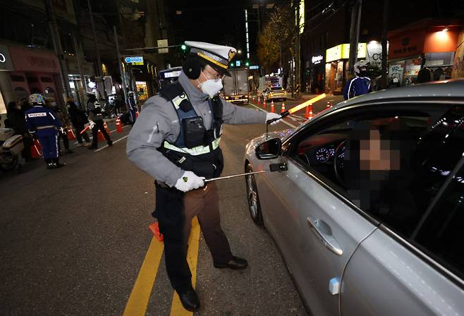 서울 마포구 도로에서 경찰들이 ‘비접촉 음주 감지기’를 이용해 음주운전 단속을 하고 있다. (사진= 연합뉴스)