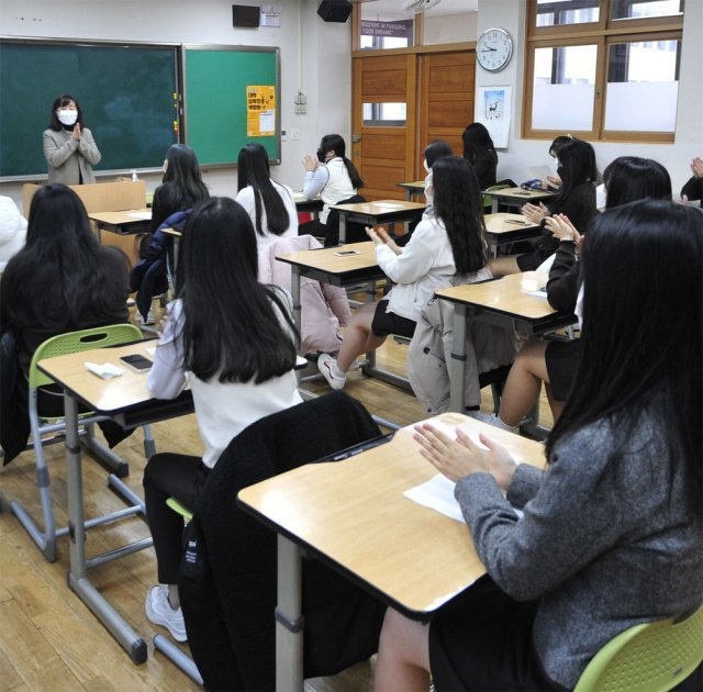 지난해 12월 23일 서울 동대문구 해성여고 학생들이 대학수학능력시험 성적표를 받고 서로에게 격려의 박수를 치고있는 모습. 사진공동취재단