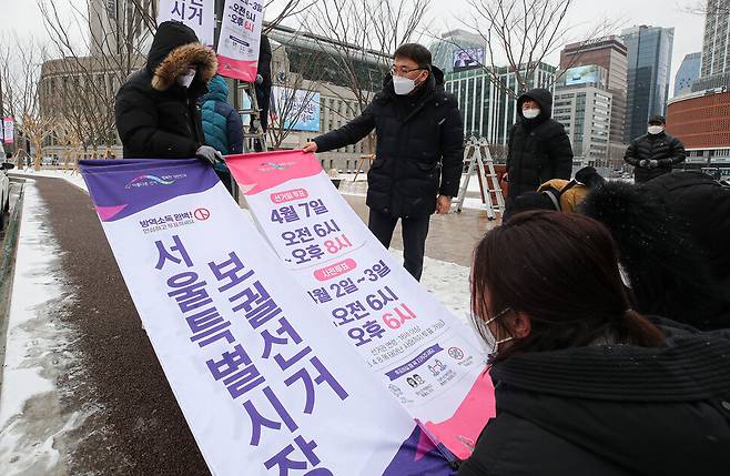 서울시장 보궐선거를 50일 앞둔 지난 16일 오후 서울 중구 서울시청 앞 광장에서 서울시 선거관리위원회 관계자들이 선거를 홍보하는 현수막을 게시하고 있다. 연합뉴스