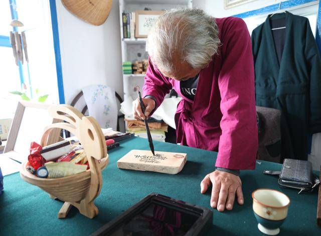 '촌장과 바다'의 차우석 작가가 손글씨를 쓰고 있다. ⓒ박준규