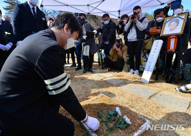 [광주=뉴시스] 변재훈 기자 = 19일 오후 광주 북구 운정동 국립 5·18민주묘지 2묘역에서 전옥주(전춘심)씨 유해 안장식이 열린 가운데 유족들이 헌화를 하고 있다. 전씨는 5·18 당시 시민 참여를 호소하는 가두 방송으로 항쟁을 이끌었다. 2021.02.19. wisdom21@newsis.com