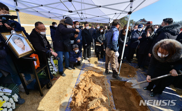 [광주=뉴시스] 변재훈 기자 = 19일 오후 광주 북구 운정동 국립 5·18민주묘지 2묘역에서 전옥주(전춘심)씨 유해 안장식이 열린 가운데 유족들이 허토를 하고 있다. 전씨는 5·18 당시 시민 참여를 호소하는 가두 방송으로 항쟁을 이끌었다. 2021.02.19. wisdom21@newsis.com