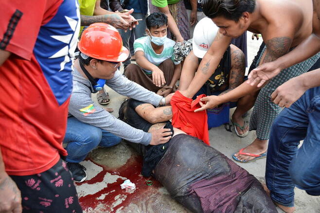 20일(현지시각) 미얀마 만달레이에서 군부 쿠데타에 저항하는 시위 도중 경찰이 쏜 총에 맞은 남성이 쓰러져 있다. 만달레이/로이터 연합뉴스