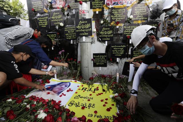 미얀마 최대 도시 양곤에서 20일 시민들이 쿠데타 규탄 시위 중 총에 맞아 숨진 여성 먀 뚜웨 뚜웨 킨을 추모하며 피격 현장 추모소에 꽃과 촛불을 놓고 있다. 양곤=EPA 연합뉴스