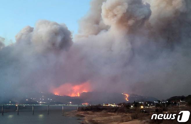 21일 오후 3시 20분쯤 경북 안동시 임동면 망천리의 한 야산에서 원인을 알 수 없는 불이 나 계속 번지고 있다. 산림 당국과 안동시 등은 소방헬기 14대와 소방차 12대, 특수진화대원 19명, 공무원, 소방관 등 560여명을 투입해 진화 작업을 벌였다. 산림 당국이 산불재난 국가 위기 경보 '심각' 단계를 발령했다.(독자제공)2021.2.21/뉴스1 불은 인근 야산으로도 확산해 중평리와 수곡리 주민들이 대피했고 임동면사무소~진보 방면 국도 34호선 일부 구간도 통제됐다. © News1 최창호 기자